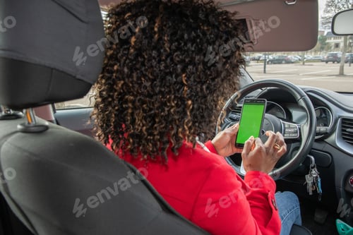 Preview: Satisfied young african american woman video chatting in car with someone