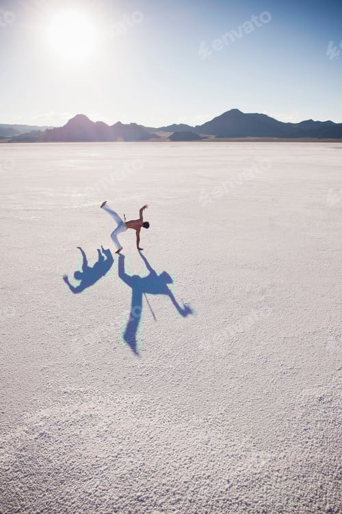 Visualização: Homem com duas sombras realizando capoeira em Bonneville Salt Flats, Utah, EUA