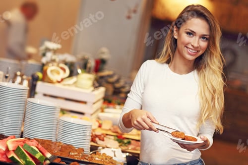 Preview: Attractive woman at breakfast buffet in hotel
