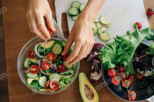 Preview: Close-up from above of female hands preparing vegetable salad.
