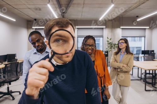 Preview: Professional diverse colleagues reviewing financial data, examining documents closely