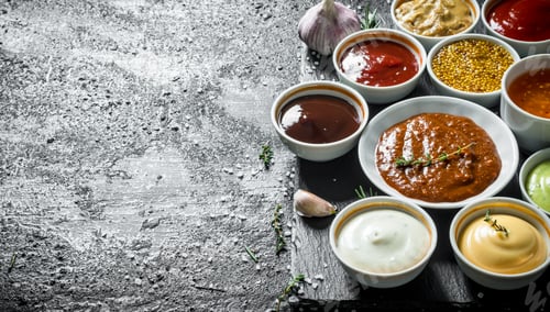Preview: An assortment of different sauces in bowls on a stone Board.