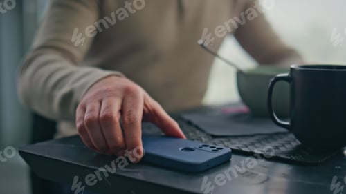 Preview: Eating man hand taking cellphone receiving notification at morning flat closeup