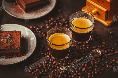 Preview: Two espresso coffee mugs with piece of chocolate cake on brown background
