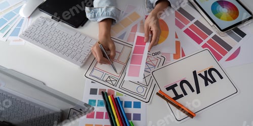 Preview: Stylish woman Ux designer using digital tablet and computer planning new website wireframe at