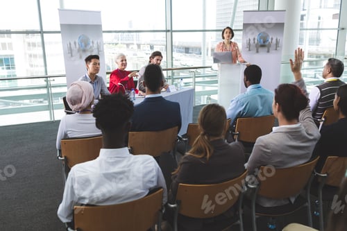 Preview: Businesswoman raising hand in business seminar in office building