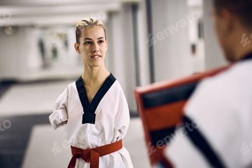 Preview: Armless taekwondo fighter having sports training with her sparring partner in health club.