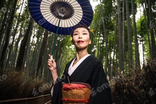 Preview: Beautiful japanese senior woman walking in the bamboo forest
