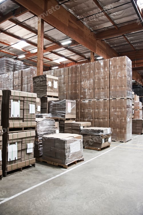 Preview: Warehouse interior showing stacks of cardboard used for packaging.