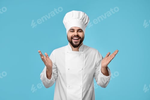 Preview: Happy young chef in uniform on light blue background