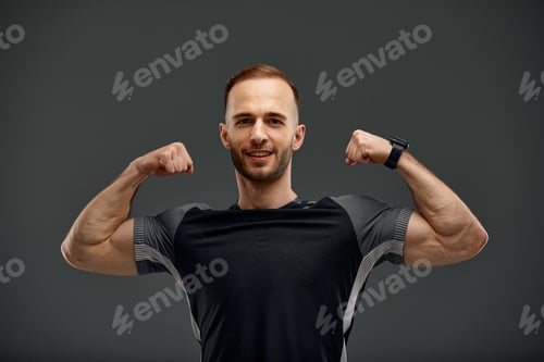 Preview: Portrait of a handsome young guy model with hairstyle in a trendy black tank top mock up with a