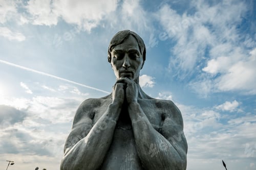 Preview: Contemplative Sculpture Against Vibrant Sky