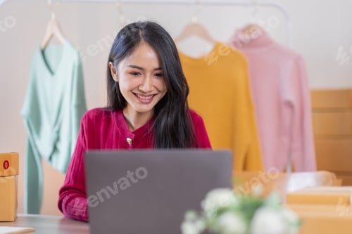 Preview: Asian women SME selling clothes online, She is answering customers' questions by phone and laptop