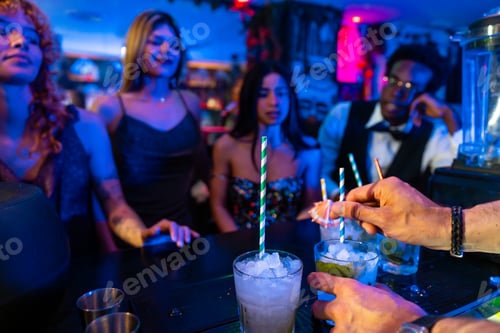 Preview: Bartender preparing cocktails for customers at nightclub bar