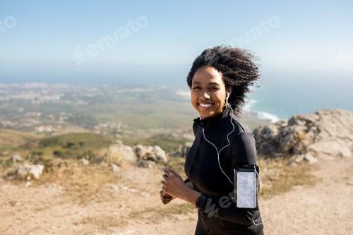 Preview: Portrait of excited black lady running and listening music, enjoying morning workout outdoors on