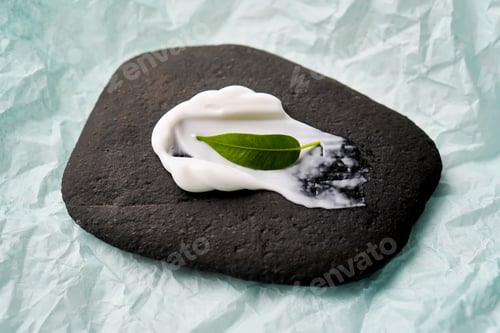 Preview: A smear of white cream on a black stone.