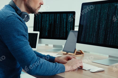 Preview: Programmer with headphones working at desk in office, closeup