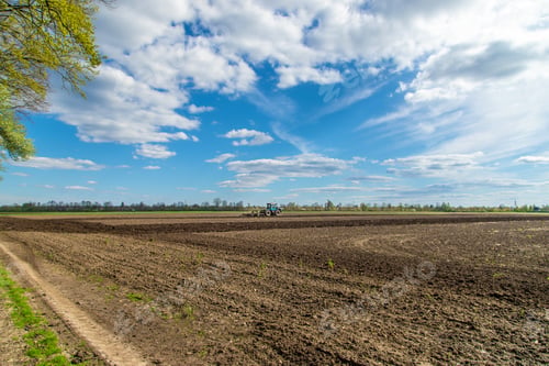 Preview: The tractor plows the soil in the field. Selective focus.
