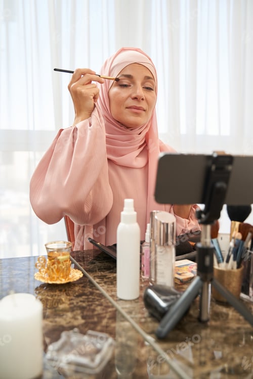 Preview: Calm lady in hijab trying natural color of cosmetics