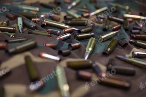 Preview: Many rifle bullets and cartridges on dark camouflage background
