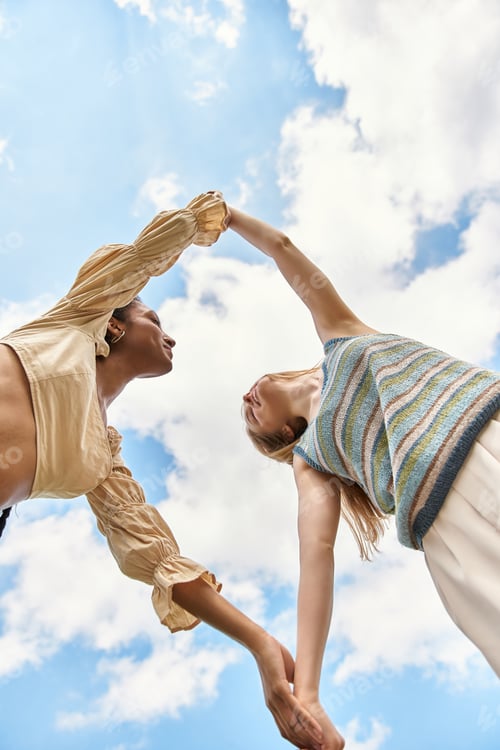 Preview: Young beautiful couple enjoys a tender moment under a bright blue sky with fluffy clouds