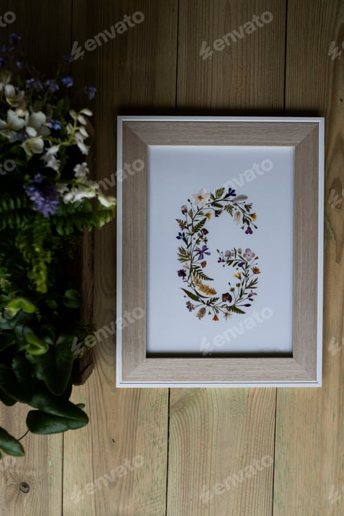 Preview: Floral letter G in wooden frame, decorations for a woodland naming ceremony.