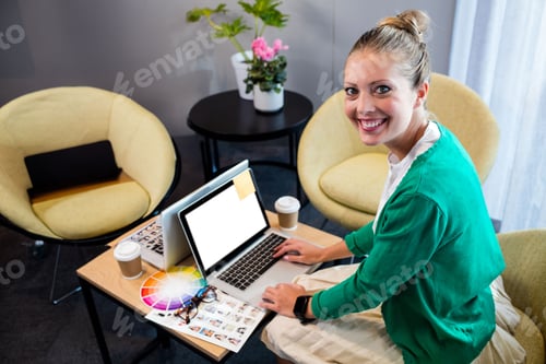 Preview: Laptop and color swatches scattering on table in lounge with two coffee cups and plant
