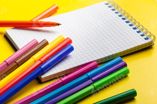 Preview: Felt-tip pens and blank notepad on bright yellow background