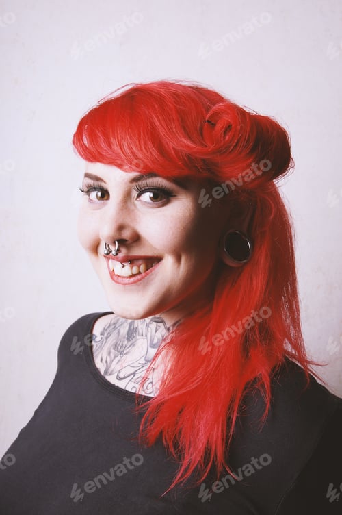 Preview: pierced and tattooed young woman with toothy smile