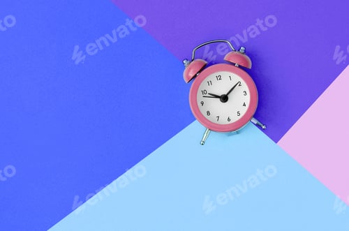 Preview: A small pink alarm clock is located between areas of blue, violet and pink colors