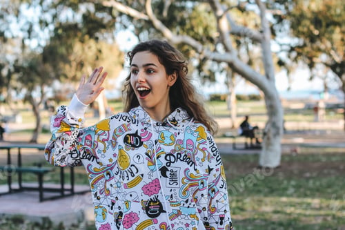 Preview: Cute young teenager girl greeting friends outdoors. School girl waving hand to her friends
