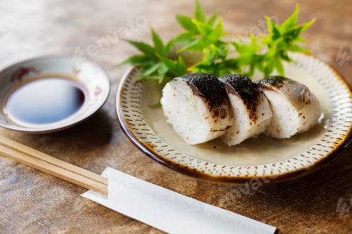 Preview: High angle close up of plate of Sushi and bowl of Soy Sauce on a table in Japanese restaurant.