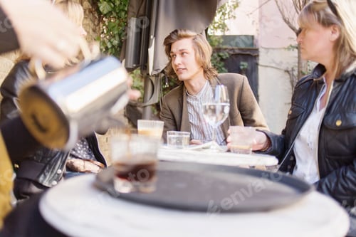 Preview: Friends enjoying a casual conversation at an outdoor caf