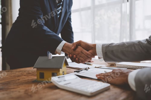Preview: Real estate broker and client shaking hands after signing sale contract, home loan and congratulatin