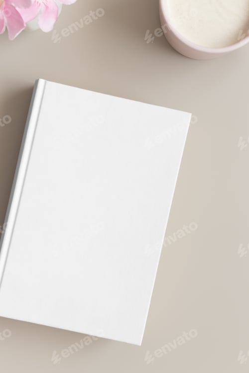 Preview: White book mockup with a cup of coffee and oleander on a beige table.