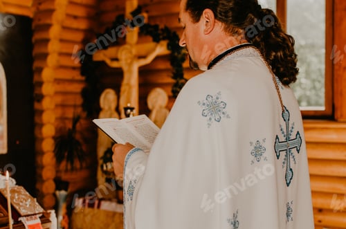 Preview: priest in cassock holds holy book of Bible and reads