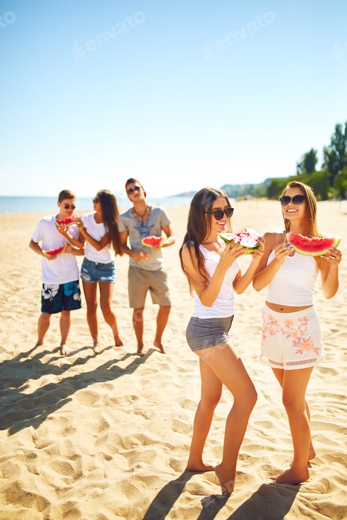 Preview: Group of friends having fun eating watermelon. on beach. Excellent sunny weather. Super mood. Summer