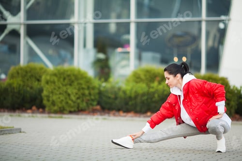 Preview: Fitness woman doing workout standing in a modern building background