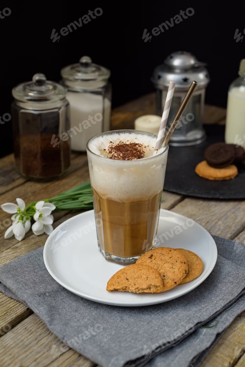 Preview: Iced coffee and cookies on a table with white flowers, condiments and candle