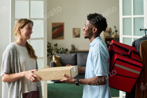 Preview: Woman Receiving Package from Black Man Courier Indoors