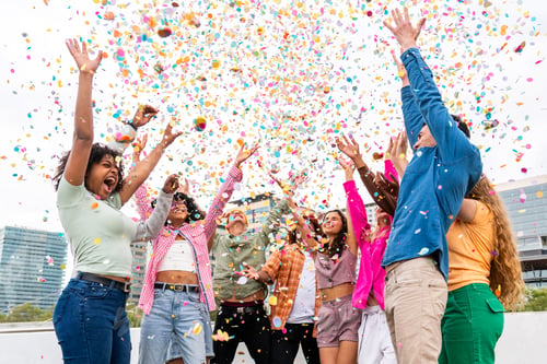 Preview: Happy playful multiethnic group of young friends bonding outdoors