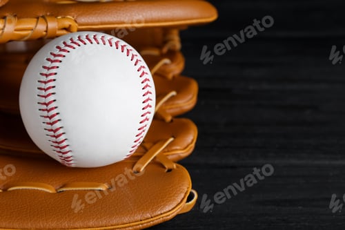 Vista previa: Catcher's mitt and baseball ball on black background, closeup with space for text. Sports game