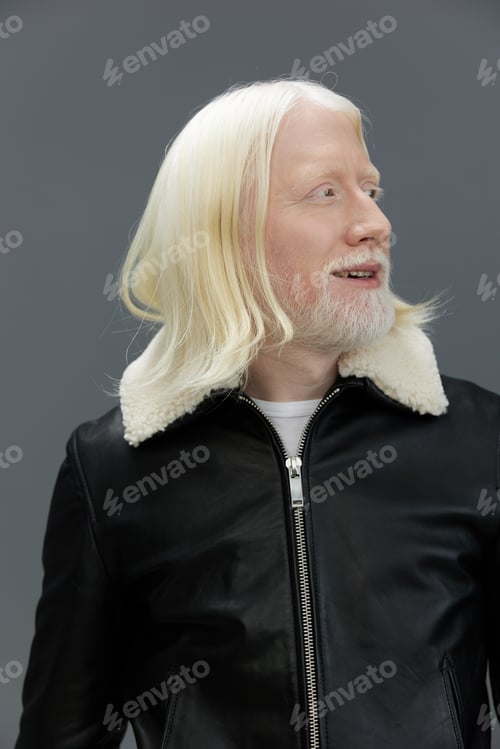 Preview: Stylish man with long white hair and beard wearing a black leather jacket with fur collar, looking
