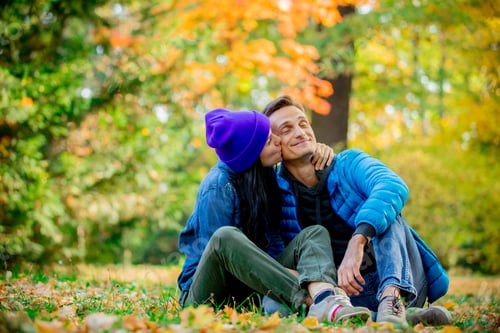 Preview: Young couple sitting on ground in a autumn season time park