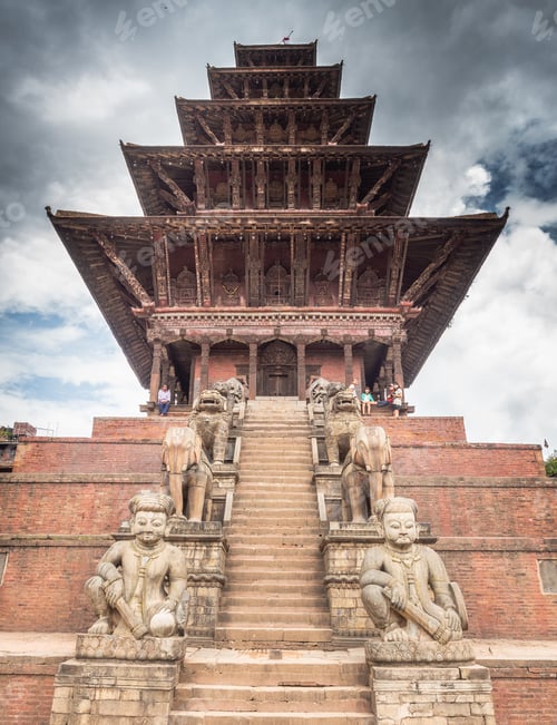 Preview: NEPAL, BHAKTAPUR - AUGUST 19, 2014: Amazing Oriental tower with sculptures and cloudy sky