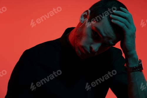 Preview: Portrait of a young confident handsome businessman in blue and red light