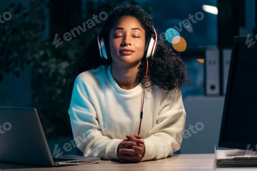 Preview: confident african woman listening to music with earphones while relaxing of work