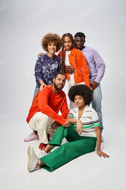 Preview: cheerful african american people in colorful casual wear spending time together on grey background