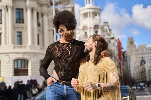 Preview: Gay couple smiling and embracing in urban setting
