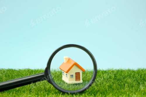 Preview: Small houses under a magnifying glass. Real estate search concept, purchase and sale of housing